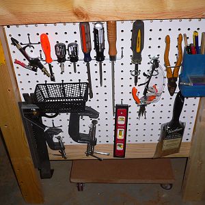 My first woodworking bench with peg board storage.